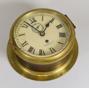 AN EARLY TWENTIETH CENTURY SHIP'S BELL BULKHEAD CLOCK with circular off white enamel dial bearing