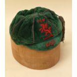 A 1925 FOOTBALL ASSOCIATION OF WALES CAP in green felt with red embroidered dragon FAW and date,