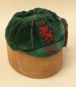 A 1925 FOOTBALL ASSOCIATION OF WALES CAP in green felt with red embroidered dragon FAW and date,
