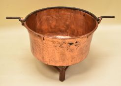 A LARGE ANTIQUE COPPER PAN on metal stand, the copper with riveted reinforcement and iron loop