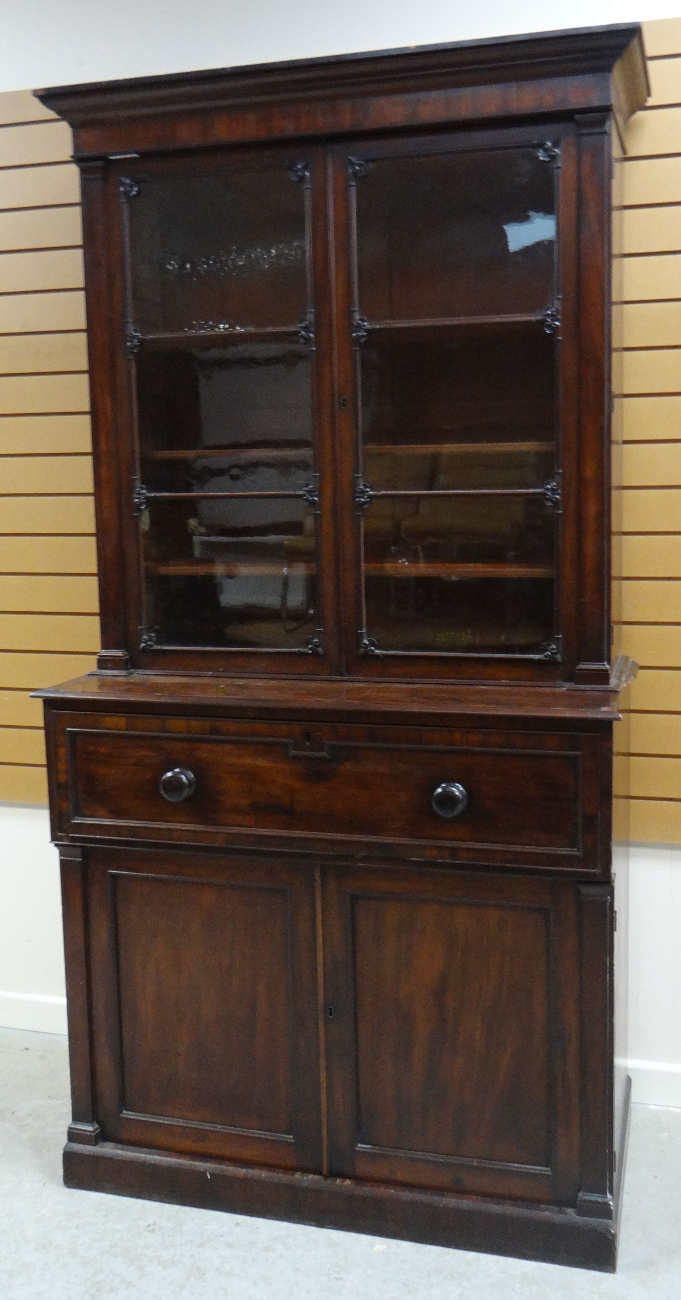 AN EMPIRE MAHOGANY SECRETAIRE BOOKCASE composed of base two-door cupboard and fold down drawer to