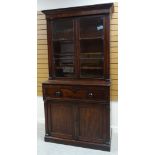 AN EMPIRE MAHOGANY SECRETAIRE BOOKCASE composed of base two-door cupboard and fold down drawer to