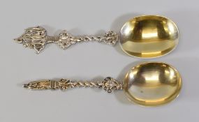 TWO SILVER SPOONS with large open bowls and both having twist stems to decorative terminals of an