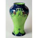 A MACINTYRE MOORCROFT BALUSTER VASE in a rare green and blue coloured reserves and with swags of