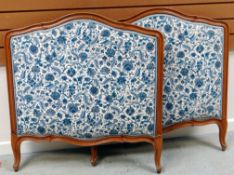 A PAIR OF FRENCH LIGHTWOOD SINGLE BED ENDS with blue & white floral upholstery