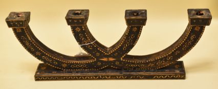 A PAINTED WOODEN FOUR BRANCH CANDLE HOLDER on a wide rectangular base and decorated in straw work,