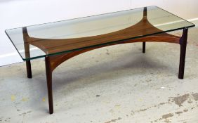 A DANISH ROSEWOOD & GLASS COFFEE TABLE comprising rosewood shaped base and clear glass top