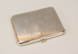 A SILVER CIGARETTE CASE opening with twin lids and machined with striping, Birmingham 1921, 5.9ozs