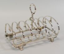 A SIX SECTION SILVER TOAST-RACK composed of opposing c-scroll rails with balloon handle and raised