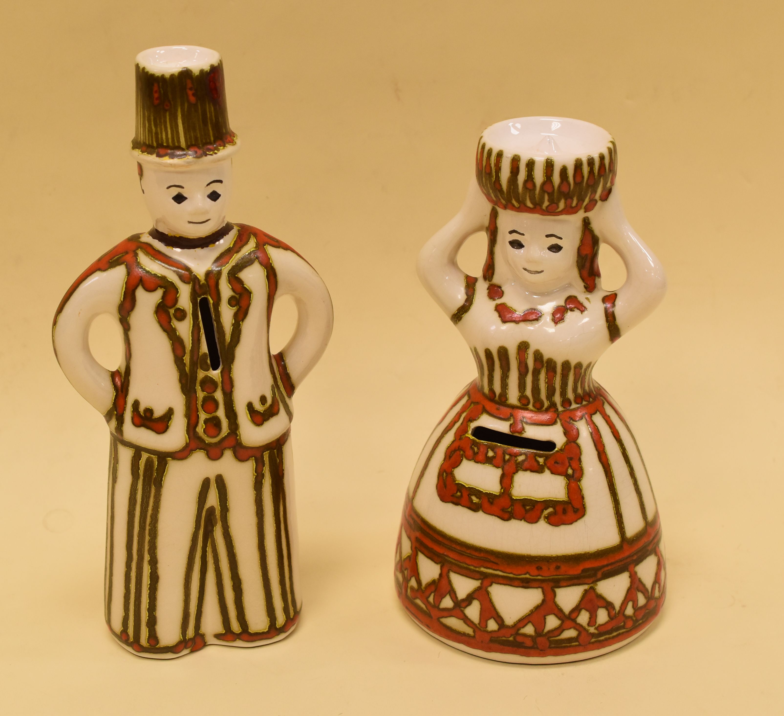 A PAIR OF GERMAN POTTERY FIGURAL MONEY-BOXES, circa 1960s and being a male and female in white