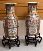 A PAIR OF FLOOR STANDING FAMILLE ROSE VASES, twentieth century, with all round decoration with