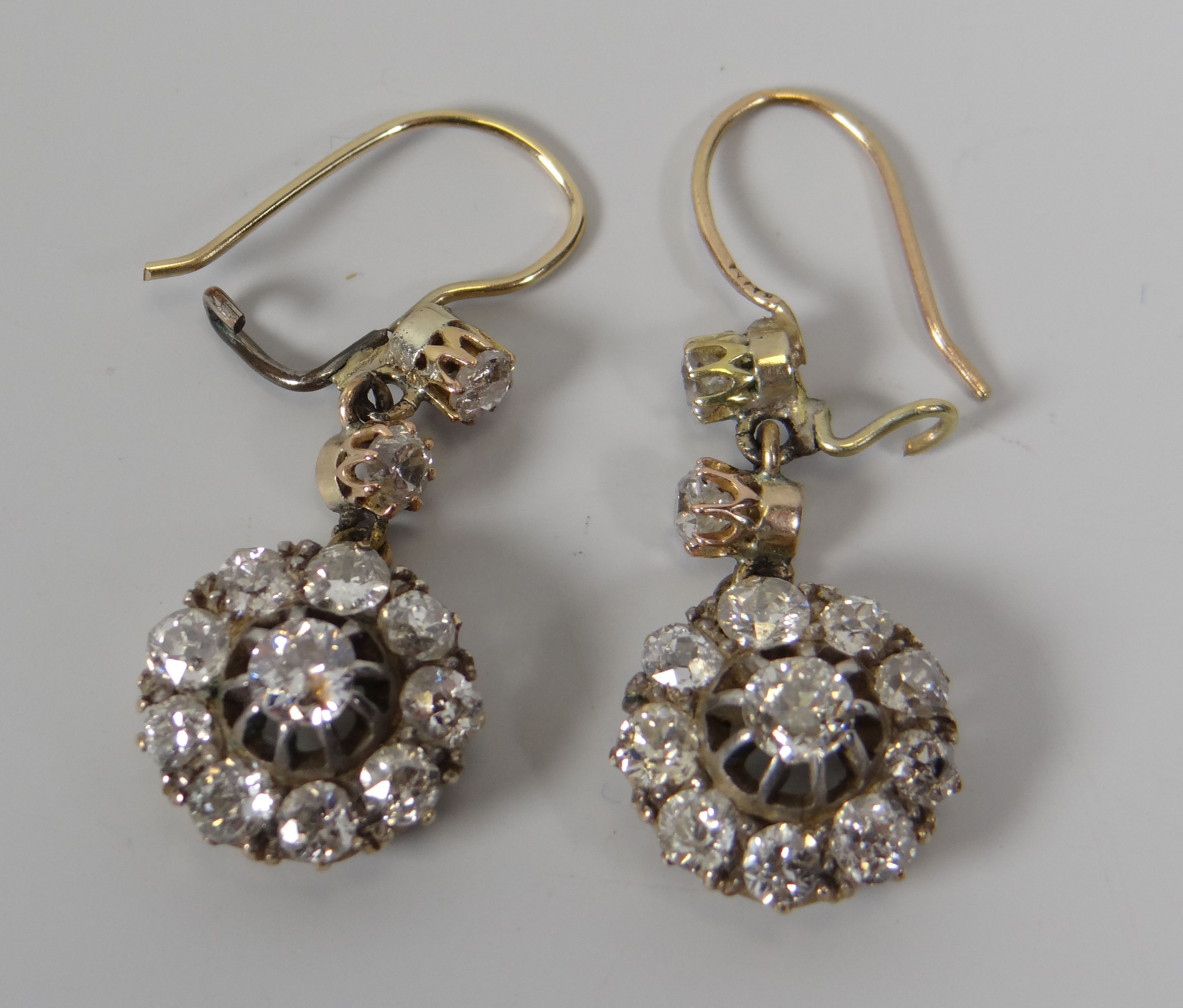A GOOD PAIR OF ANTIQUE DIAMOND CLUSTER EARRINGS each cluster composed of ten round brilliant cut - Image 2 of 3