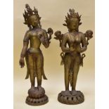 A PAIR OF METALLIC STANDING BUDDAH FIGURES, on circular decorative bases, 83cms high