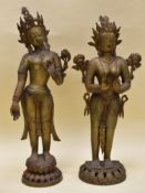 A PAIR OF METALLIC STANDING BUDDAH FIGURES, on circular decorative bases, 83cms high