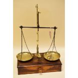 A SET OF 1920s AVERY BRASS PILLAR SCALES on a wooden base with single long drawer, the pans of