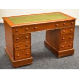 A MAHOGANY KNEEHOLE DESK with tooled green leather top and bank of nine drawers, 119cms wide