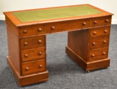 A MAHOGANY KNEEHOLE DESK with tooled green leather top and bank of nine drawers, 119cms wide