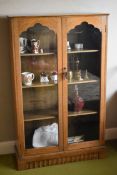 A VINTAGE OAK TWO-DOOR GLAZED BOOKCASE, 76cms wide