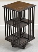 A VINTAGE REVOLVING BOOK STAND on four caster supports, 39 x 70cms