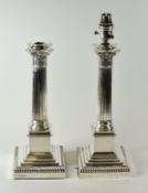 A PAIR OF SILVER LAMP-BASES of Classic architectural form with floral terminals over Corinthian
