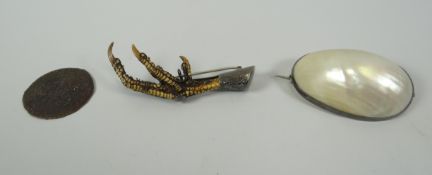 AN EARLY COIN (DISTRESSED) & TWO BROOCHES one with a mounted talon, the other with mother-of-pearl