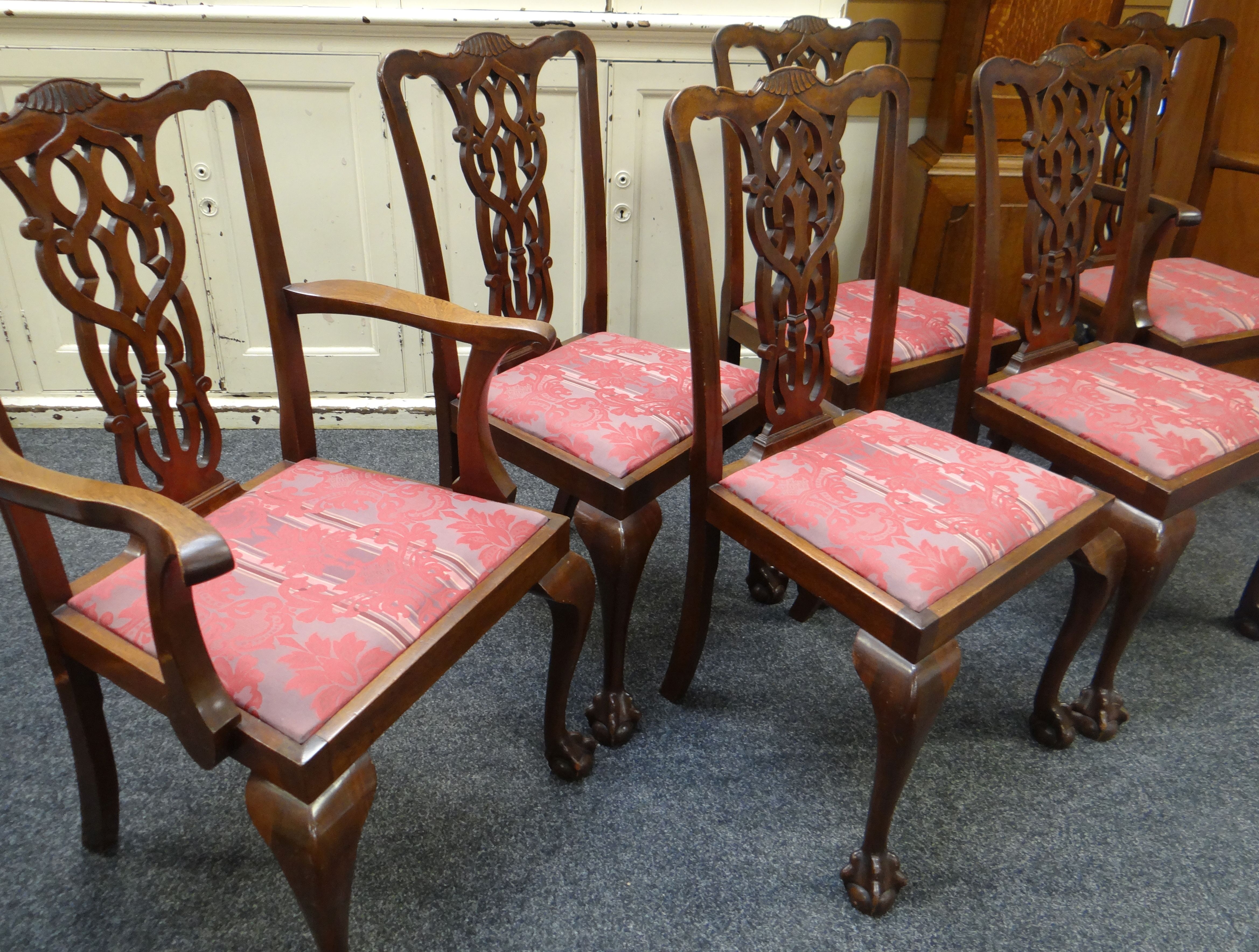 A SET OF SIX CHIPPENDALE-STYLE DINING CHAIRS with elaborate backs and ball and claw feet having drop