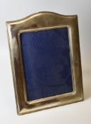 A CONTINENTAL SILVER EASEL PORTRAIT FRAME of plain form with arched top, marked 925, for photo 23.