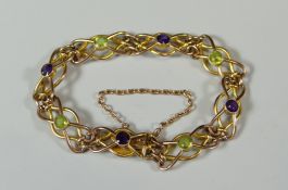 A 9CT CELTIC LINK BRACELET set with eight green and purple jewels, 10gms