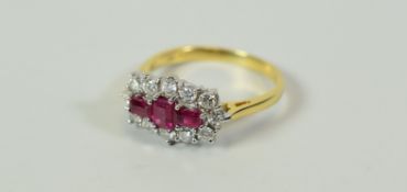 A GOOD DIAMOND & RUBY CLUSTER RING composed of three baguette rubies with twelve surrounding
