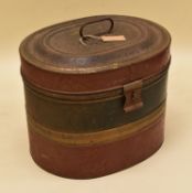 A VINTAGE PAINTED TIN HAT BOX of oval form with clasp and original handle, painted in green and