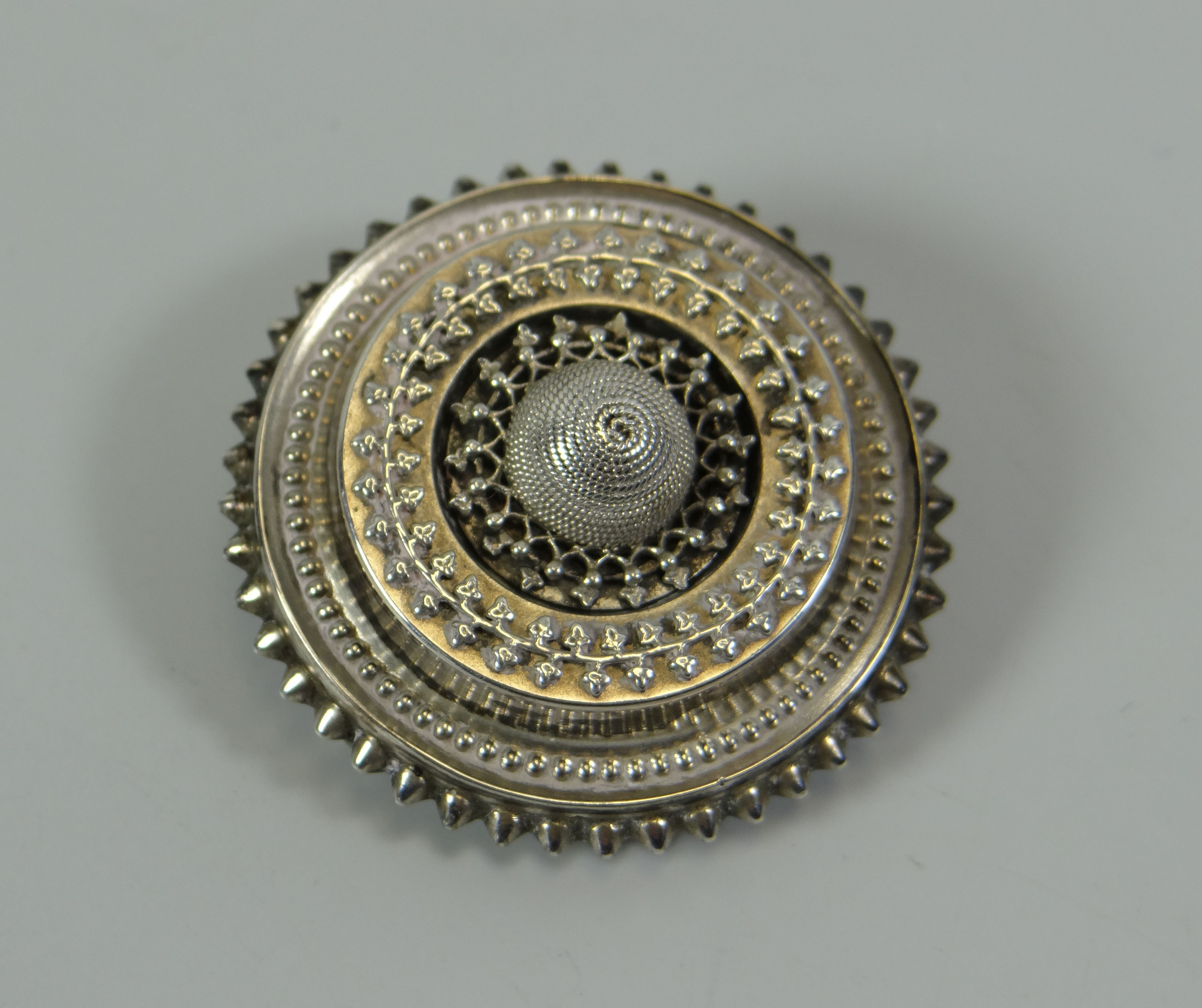 AN ANTIQUE SILVER TARGET BROOCH having a locket verso