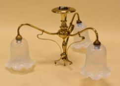 A GOOD ART NOUVEAU BRASS LIGHT FITTING having three branches with Vaseline glass pendant lights,