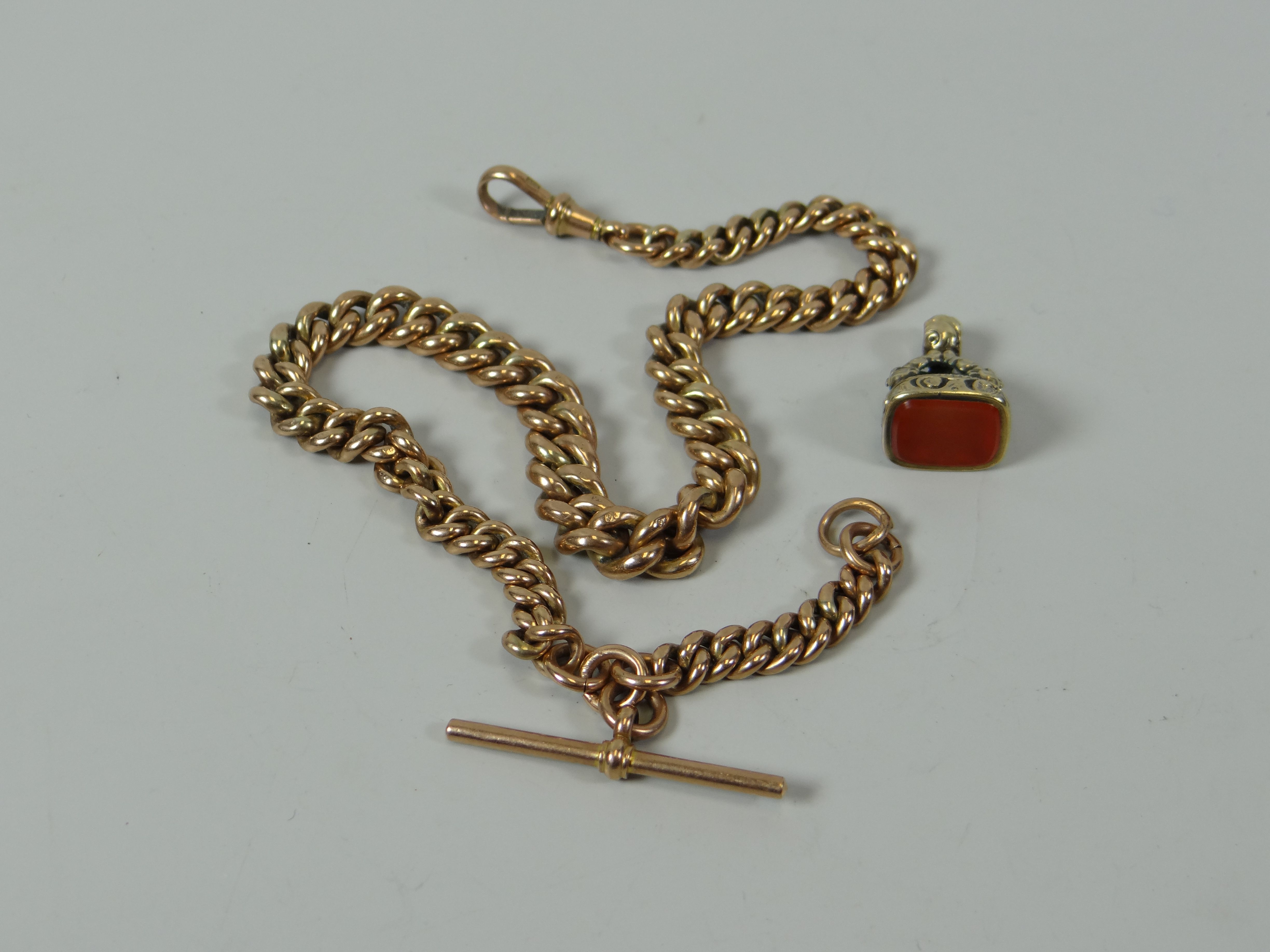 A 9CT GOLD GRADUATED MUFF-CHAIN with t-bar, 26gms; together with a fob