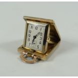 A 9CT YELLOW GOLD FOLDING MINIATURE TRAVEL CLOCK, having a machine-turned outer-case and with square