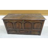 AN EARLY NINETEENTH CENTURY OAK COFFER CHEST having a four-ogee panelled facade and with two plank