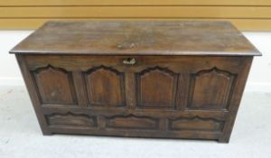 AN EARLY NINETEENTH CENTURY OAK COFFER CHEST having a four-ogee panelled facade and with two plank