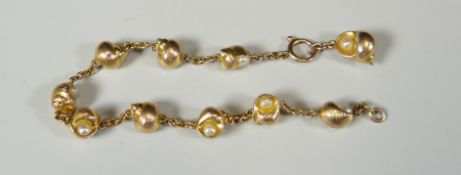 A 9CT GOLD CHAIN BRACELET OF INTERSPERSED SHELLS with each shell set with a natural pearl, marked '