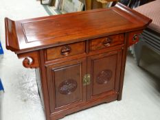A MODERN CHINESE ROSEWOOD SIDE TABLE in the altar-style with cupboard doors and two drawers, 92cms