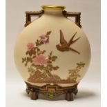 A ROYAL WORCESTER MOON FLASK having twin handles and raised on four feet in ivory ground and