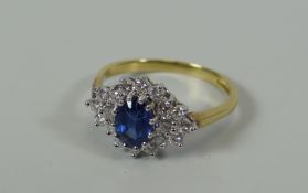 A GOOD DIAMOND & SAPPHIRE FLORAL CLUSTER RING IN 18CT YELLOW GOLD composed of centre oval sapphire