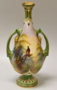 A ROYAL WORCESTER TWIN HANDLED NARROW NECKED VASE on a footed base and painted with perched and