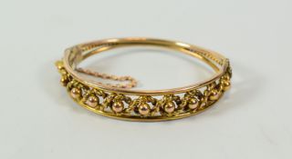 A 9CT GOLD BANGLE of openwork design with a rope twist and a series of spheres to the centre, 14gms