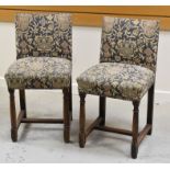A PAIR OF FRENCH STOOLS on oak supports and with buttoned heraldic tapestry