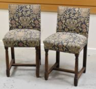 A PAIR OF FRENCH STOOLS on oak supports and with buttoned heraldic tapestry