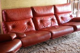 A STYLISH RED LEATHER THREE-PIECE SUITE comprising a pair of swivel armchairs and a modular