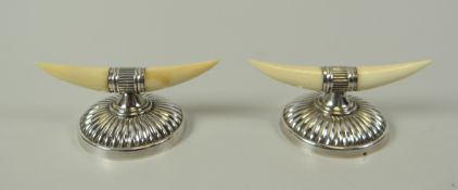 A PAIR OF SILVER & IVORY-TOOTH KNIFE RESTS with circular gadrooned convex bases, James Dixon & Sons,