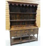 AN OAK WELSH DRESSER BASE with a good borded rack with two shelves, shaped sides and with old hooks,