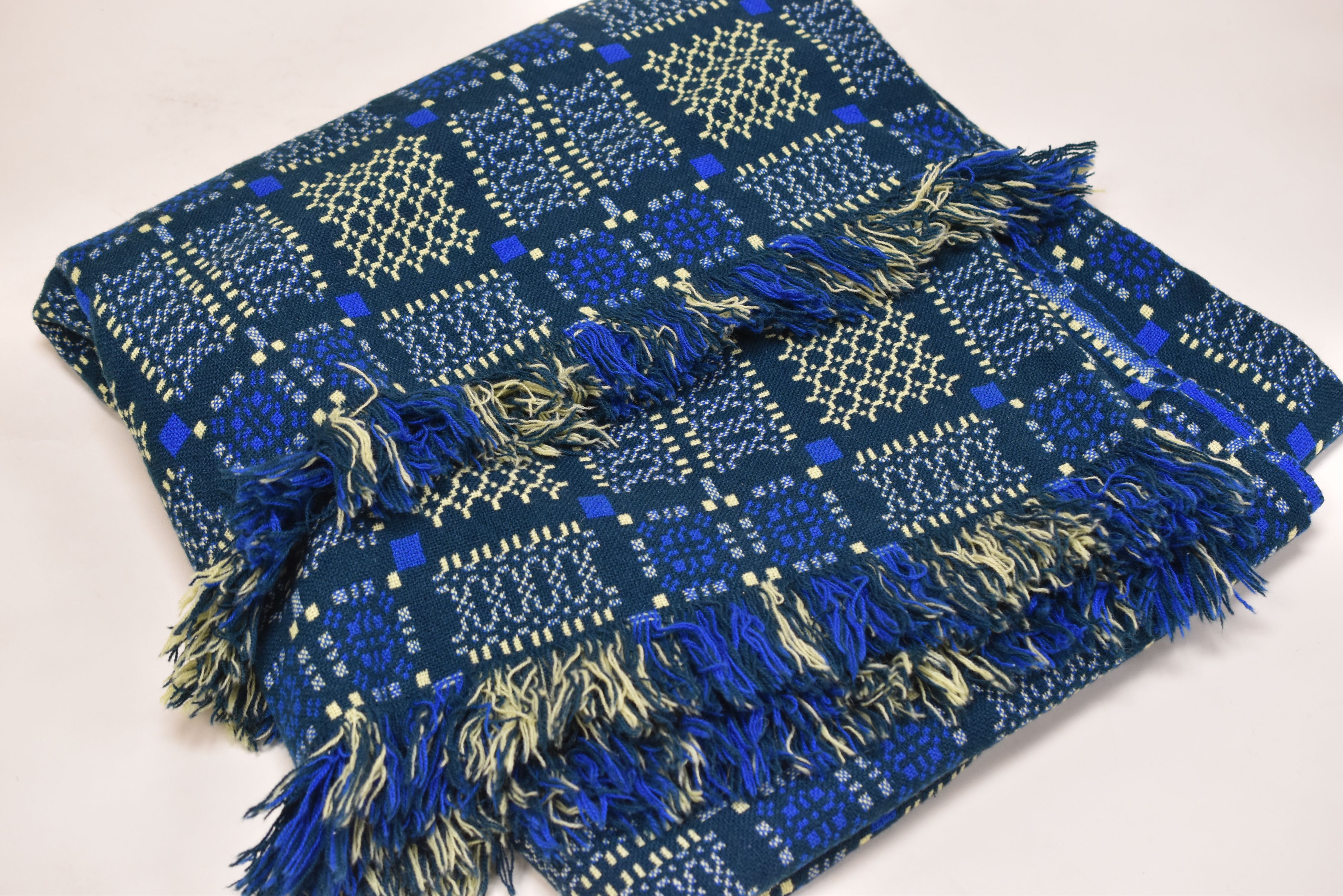A WELSH WOOL BLANKET with blue and green reserve and yellow geometric patterning, 218 x 230cms