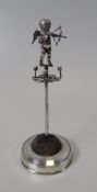 A SILVER 'CUPID' HAT-PIN STAND with pin-cushion, ring tree and hat-pin holder combined, on a