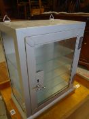 A vintage metal and glass retailers table top cabinet